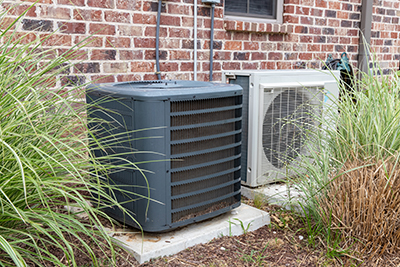 Regular home HVAC air conditioner system and mini-split next to each other.