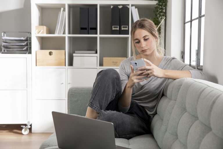 freelancer sitting couch with phone